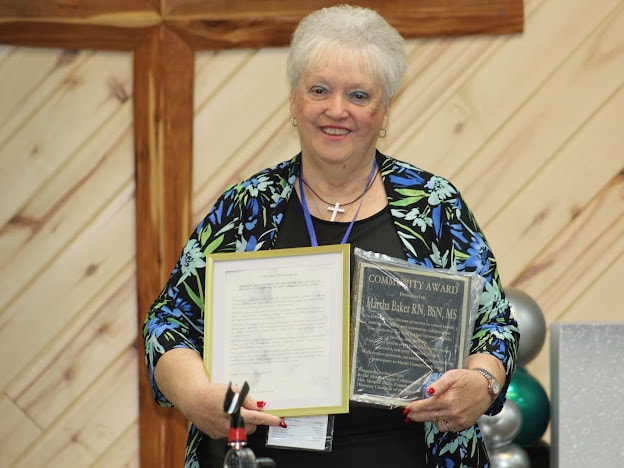 2025 Awards — Martha Baker holding Community Award plaque